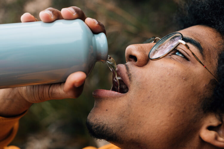 Man drinking water from a bottle, emphasizing clean well water testing