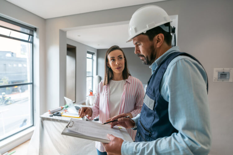 A homeowner and inspector discussing plans during a new home construction inspection